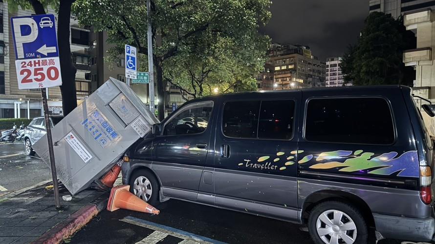 舊衣回收箱遭強風吹倒，重擊停放轎車，造成嚴重損壞。(圖/今大條新聞網拍攝)