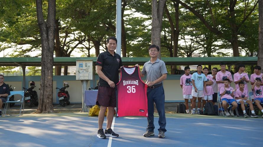 總教練邱大宗致贈球衣給陽明國中男籃總教練吳昌和。（圖／鋼鐵人提供）